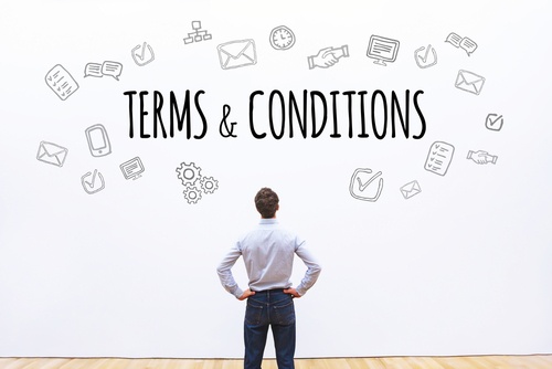 Man looking at a wall that has terms and conditions on it.