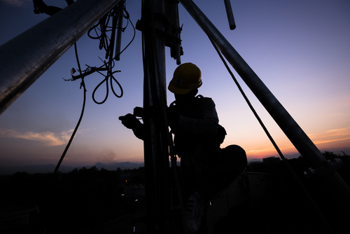 Tower Technician climbing cell tower at Night
