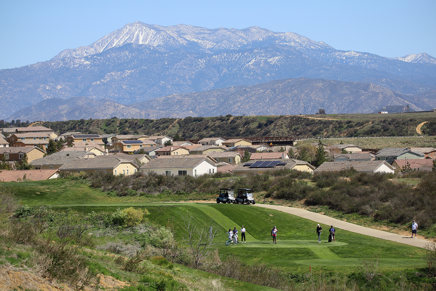 Golfing view with mountains and houses